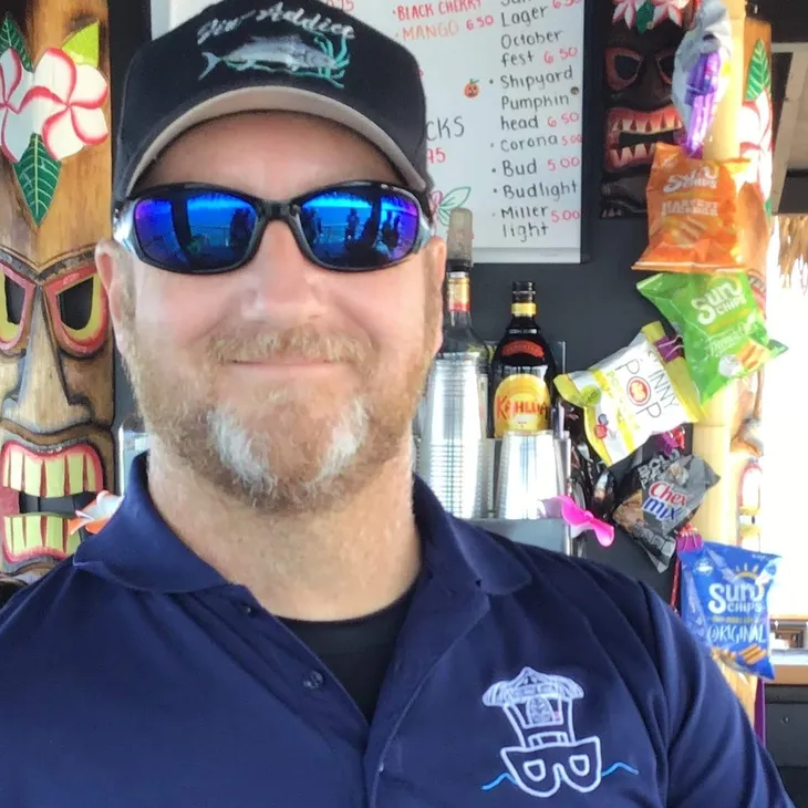 Man in sunglasses and cap at tiki bar